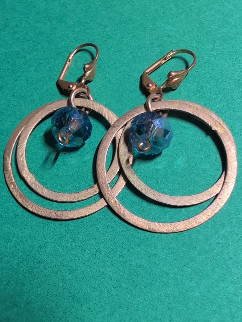 Mona Reeva Gold Tone Hoop Earrings with Blue Crystal Accent